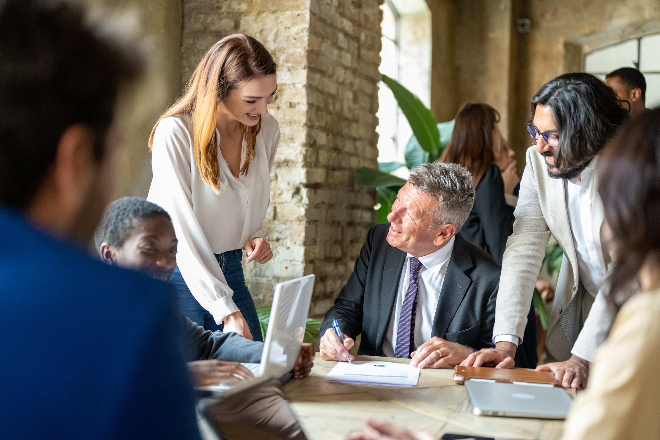 Portrait of a mature businessman signing important documents for acquisition of capital and real estate or other business, context of work of high finance and formal clothes